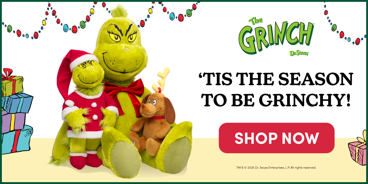 The Grinch by Dr. Seuss holiday collection featuring a giant size Grinch plush with a red bow, a regular size Grinch plush dressed in a Santa outfit, and Max the dog plush wearing antlers. Festive string lights and illustrated wrapped gifts frame the scene. Text reads: The Grinch. ’TIS THE SEASON TO BE GRINCHY! SHOP NOW.