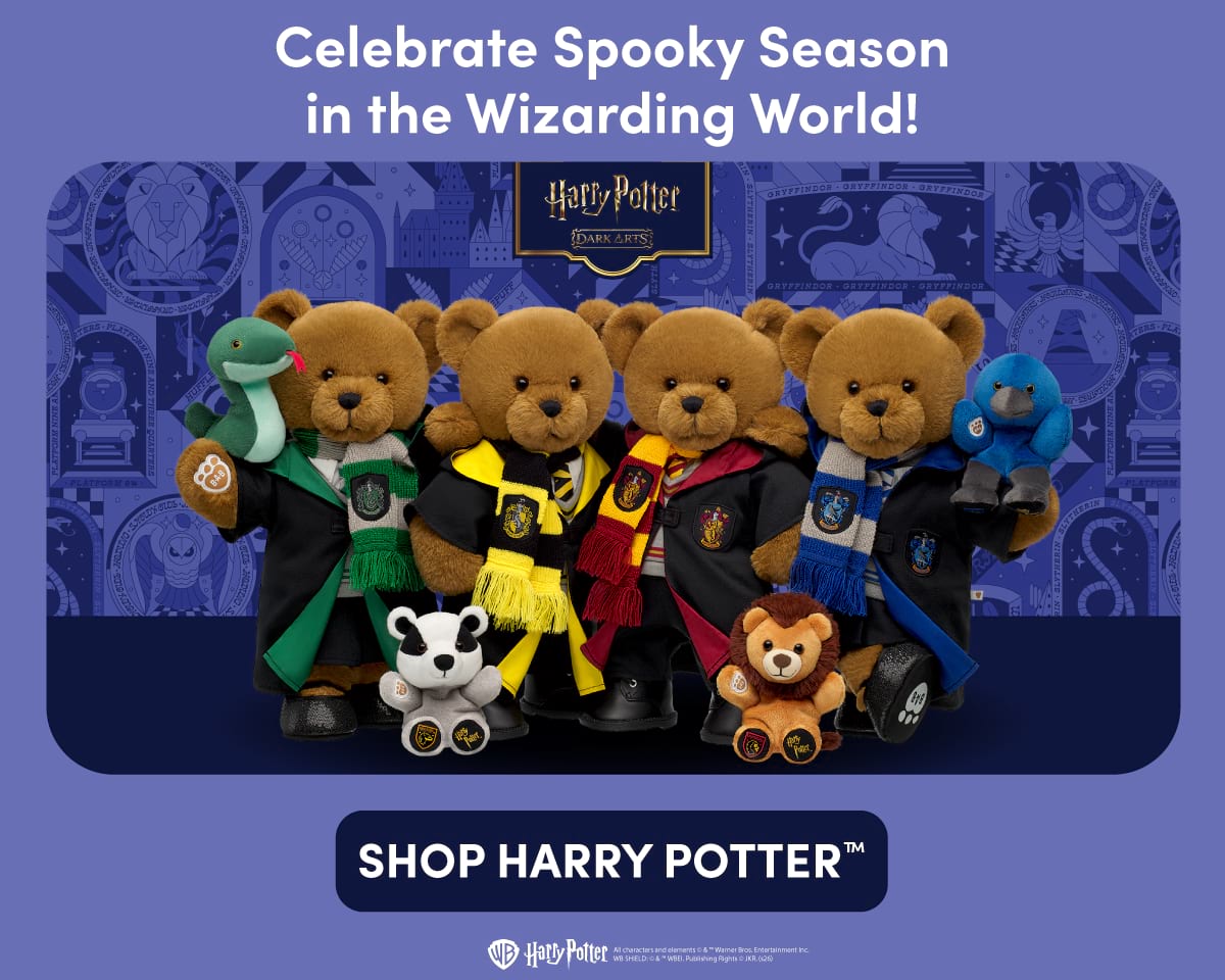 Harry Potter Dark Arts collection graphic featuring four Build-A-Bear teddy bears dressed in Hogwarts house robes and scarves. A Slytherin bear holds a green snake plush, a Hufflepuff bear stands beside a badger plush, a Gryffindor bear stands beside a lion plush, and a Ravenclaw bear holds a blue raven plush. The Harry Potter Dark Arts logo appears above against a blue illustrated Hogwarts-themed background. Text reads Celebrate Spooky Season in the Wizarding World! and SHOP HARRY POTTER™.
