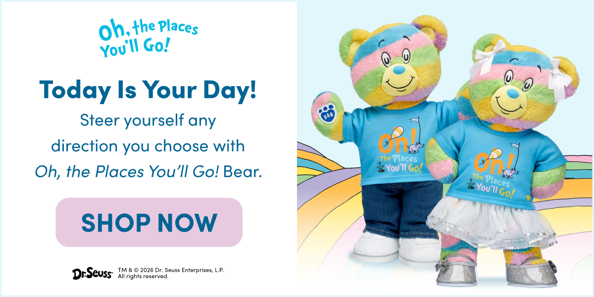 Oh, the Places You'll Go! Today Is Your Day! Two rainbow-striped Oh, the Places You'll Go! Bear plush characters stand on a colorful Dr. Seuss-inspired pathway, wearing matching blue T-shirts featuring Oh, the Places You'll Go! artwork. One bear is dressed in jeans and sneakers, while the other wears a white skirt with silver shoes and white hair bows. Text reads: Oh, the Places You'll Go! Today Is Your Day! Steer yourself any direction you choose with Oh, the Places You'll Go! Bear. SHOP NOW