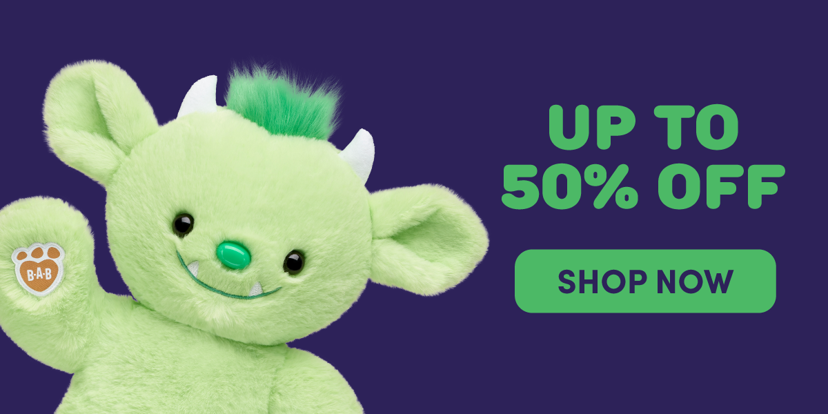 A bright green monster plush with large ears, small white horns, a green mohawk, and tiny fangs waves against a dark purple background. Text reads: UP TO 50% OFF. SHOP NOW.